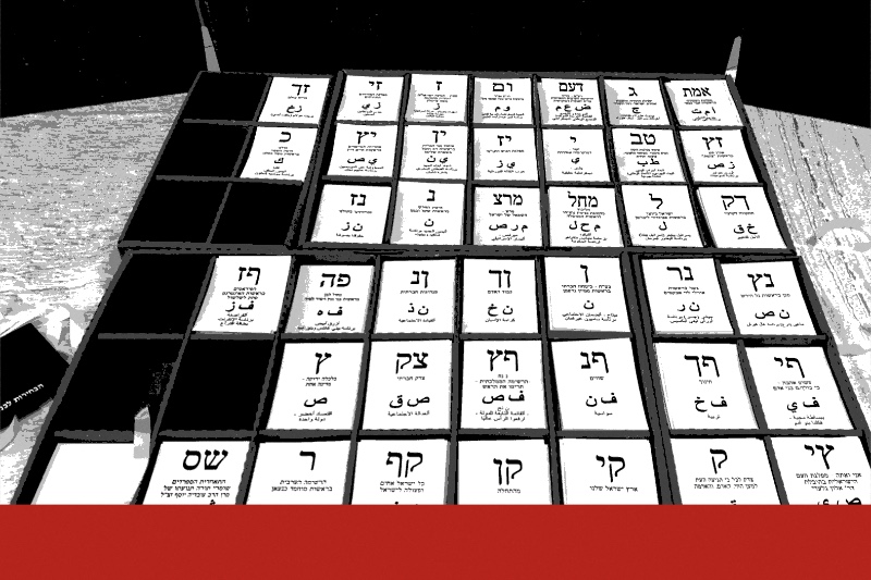 Trays of Israeli ballot slips, each printed with a list's letters in Hebrew and Arabic, laid out in a polling booth, in near black and white with a flat red band along the bottom edge