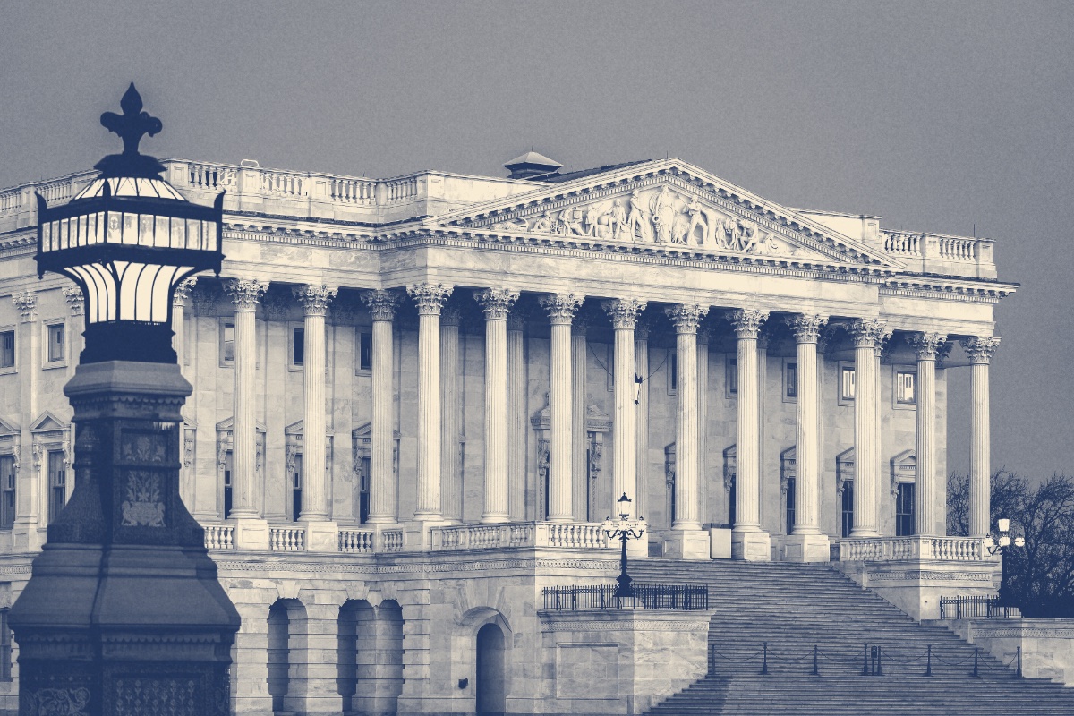The Senate wing of the United States Capitol at dusk, a marble portico of Corinthian columns above a broad flight of steps with an ornate lamp post in the foreground, in a slate and bone duotone