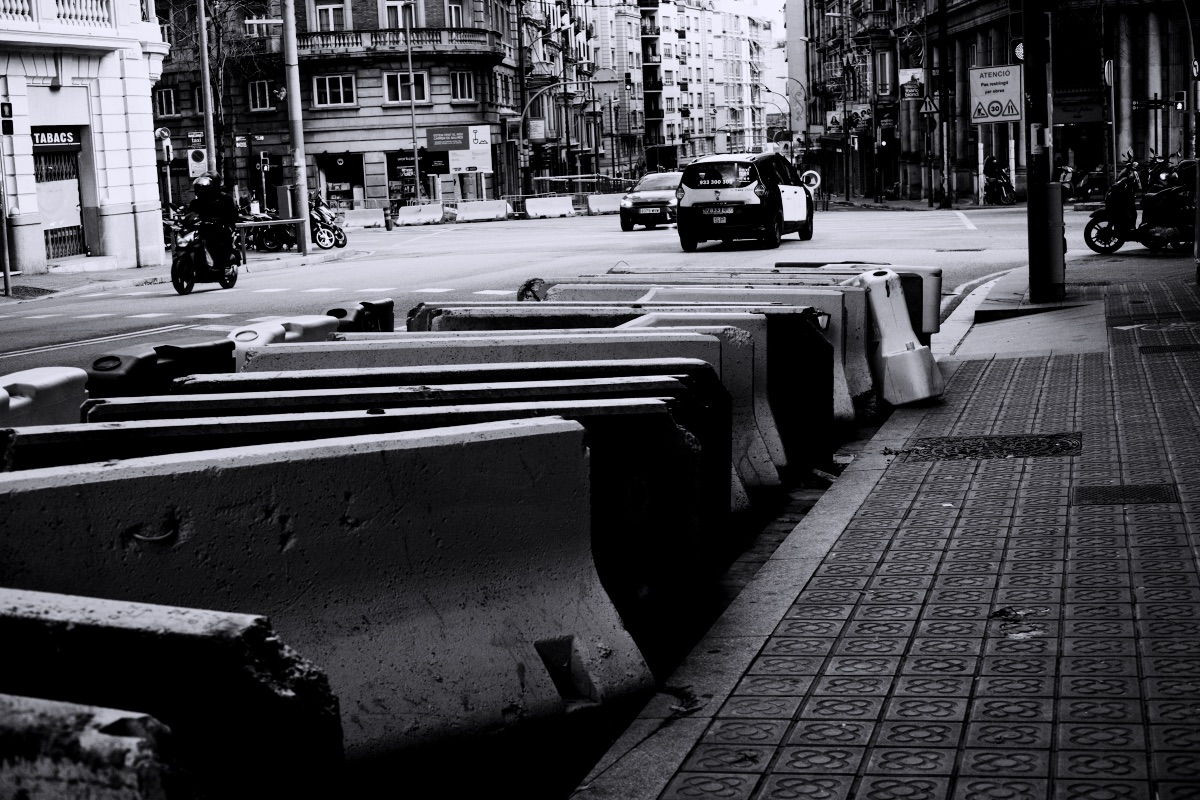 Concrete barriers line a city street with traffic