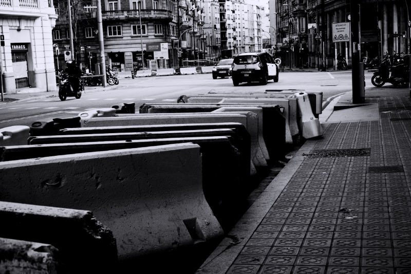 Concrete barriers line a city street with traffic