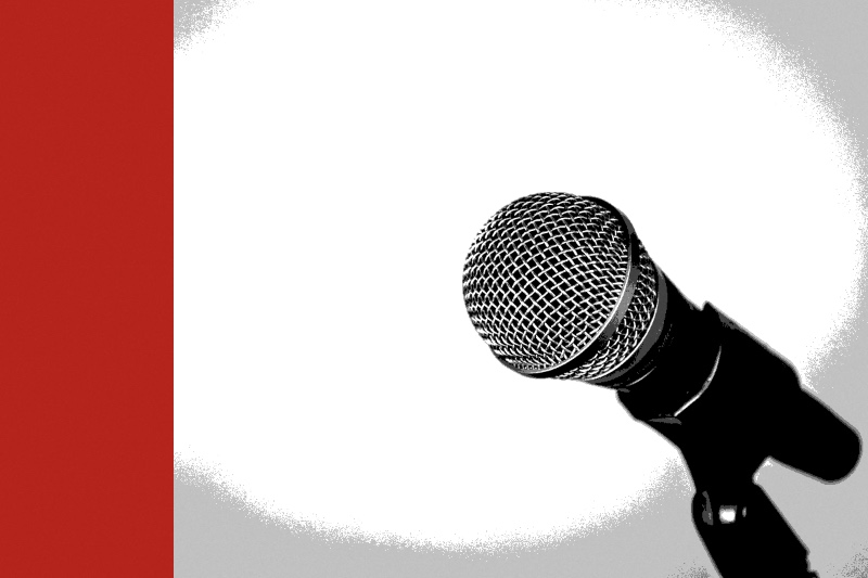 A microphone on a stand against a yellow background