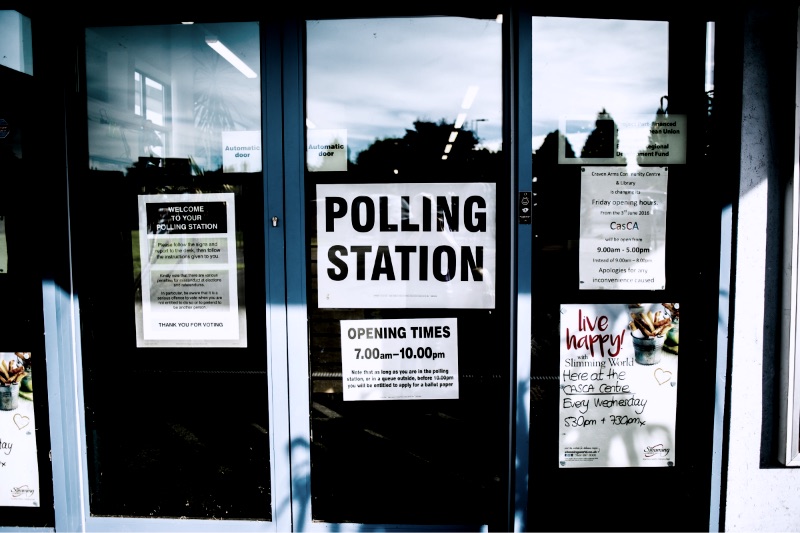 A polling station notice taped to a glass door