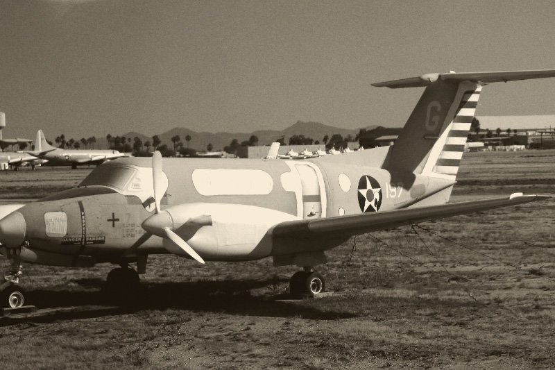 Military aircraft parked in a desert storage yard, in a warm duotone