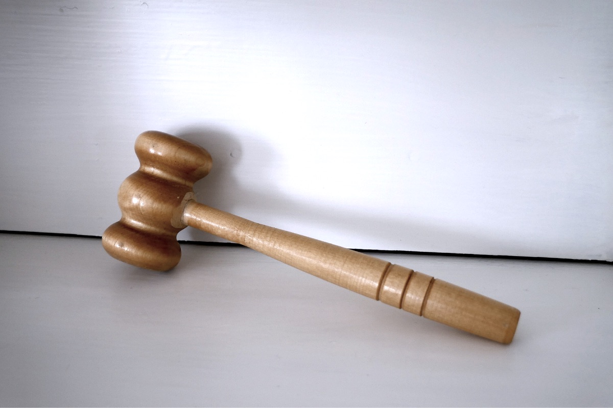 A wooden gavel resting on a plain surface