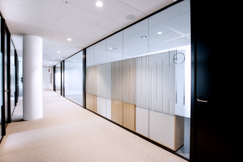 A hallway with glass walls and a clock on the wall