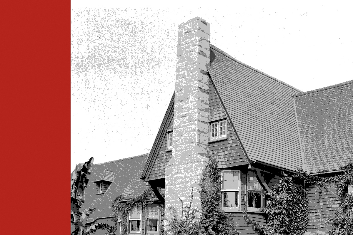A large ivy-covered residence with a stone chimney, banded in the house treatment