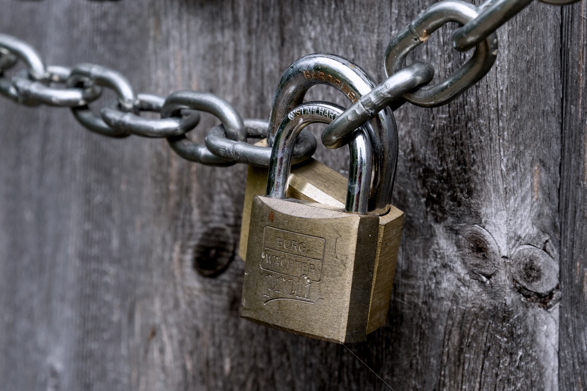 Brown padlock on brown wooden fence