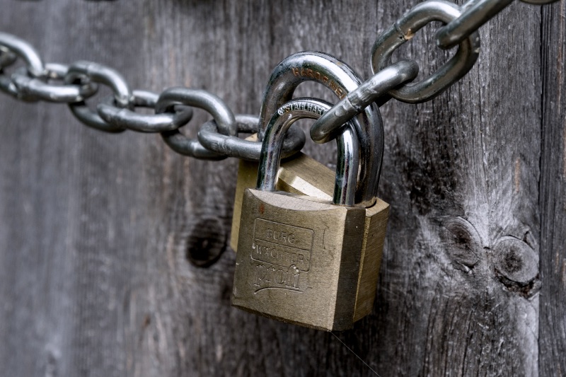 Brown padlock on brown wooden fence