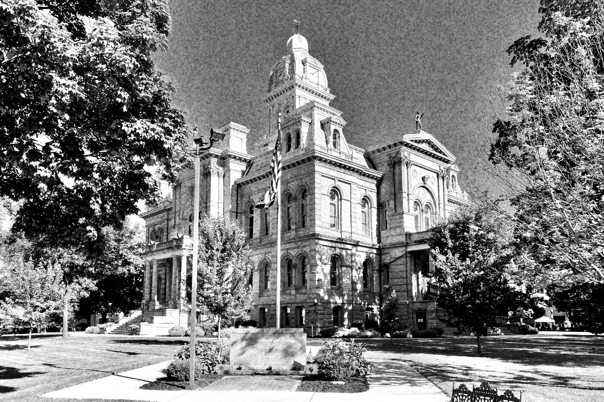 A nineteenth century county courthouse with a flag and lawn, in high contrast black and white with coarse grain