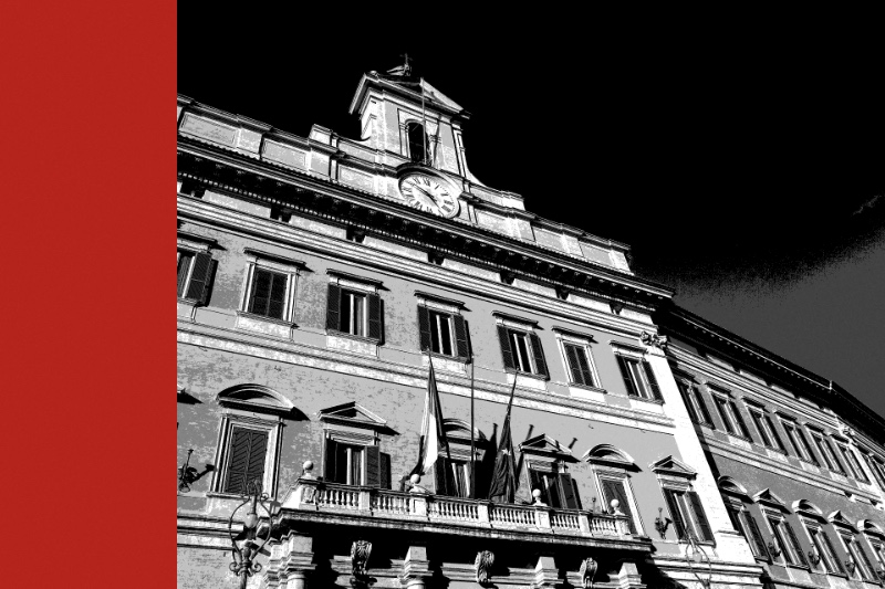 The facade of Palazzo Montecitorio in Rome seen from below, its clock tower against the sky and two flags hanging from the central balcony, in near black and white with a flat red bar down the left edge of the frame