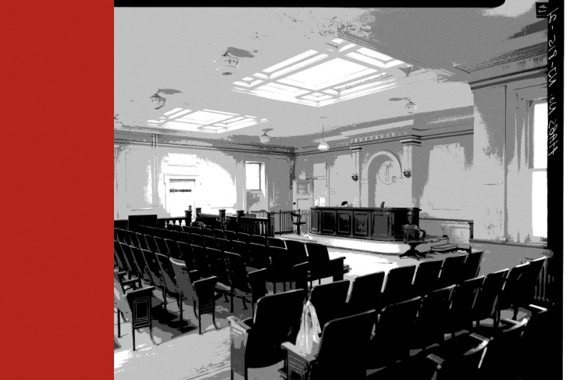 An empty municipal courtroom with rows of seats, banded in the house treatment
