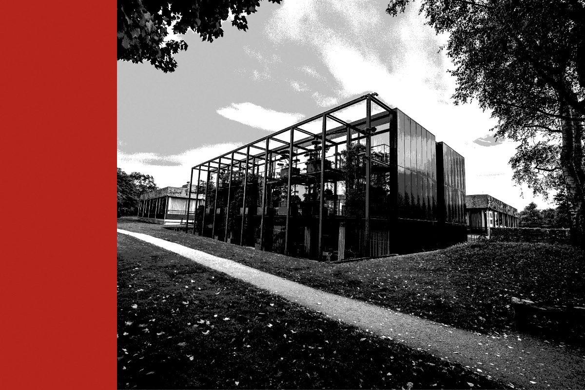 The glass and dark steel pavilion of the Federal Constitutional Court in Karlsruhe beside a lawn, with a red bar at the left edge