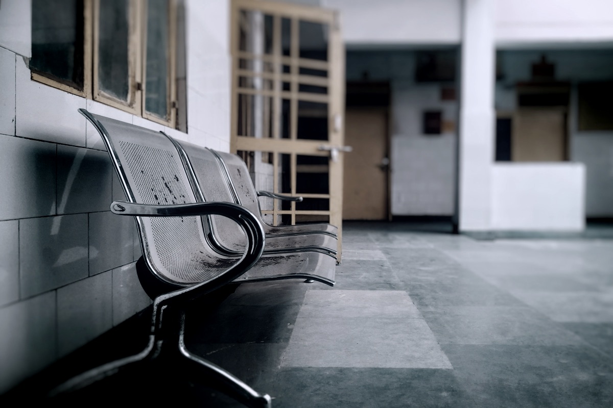 A metal bench sitting next to a wall