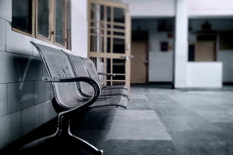 A metal bench sitting next to a wall