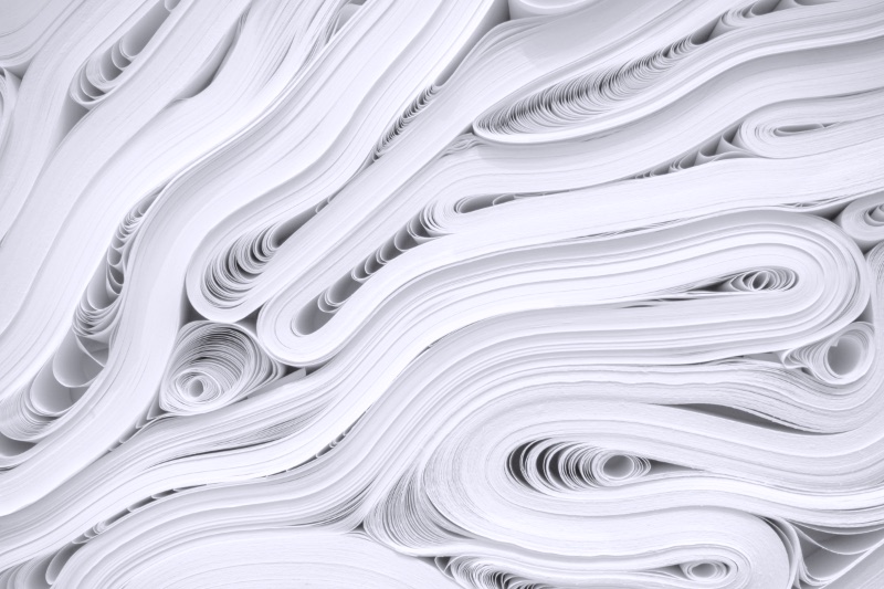 Curving layers of white paper creating an abstract pattern of flowing lines