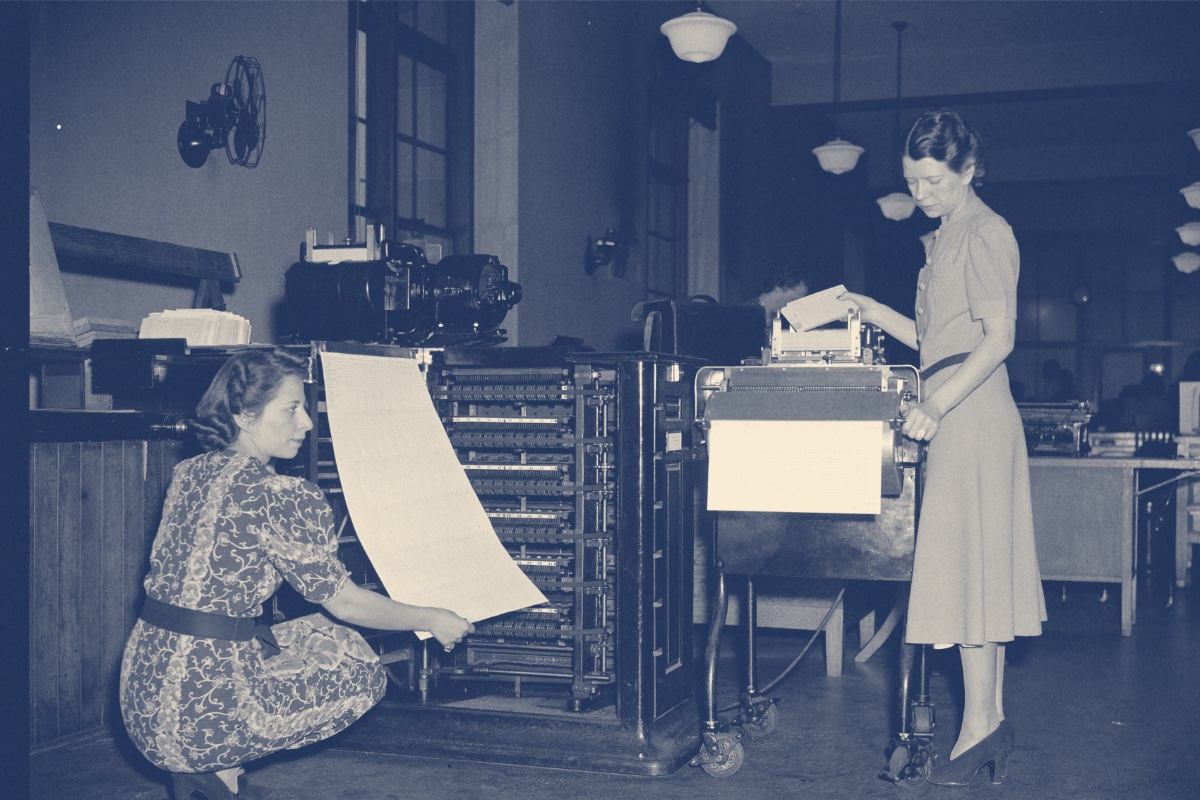 Two operators working a census tabulating machine in 1940, in a blue duotone
