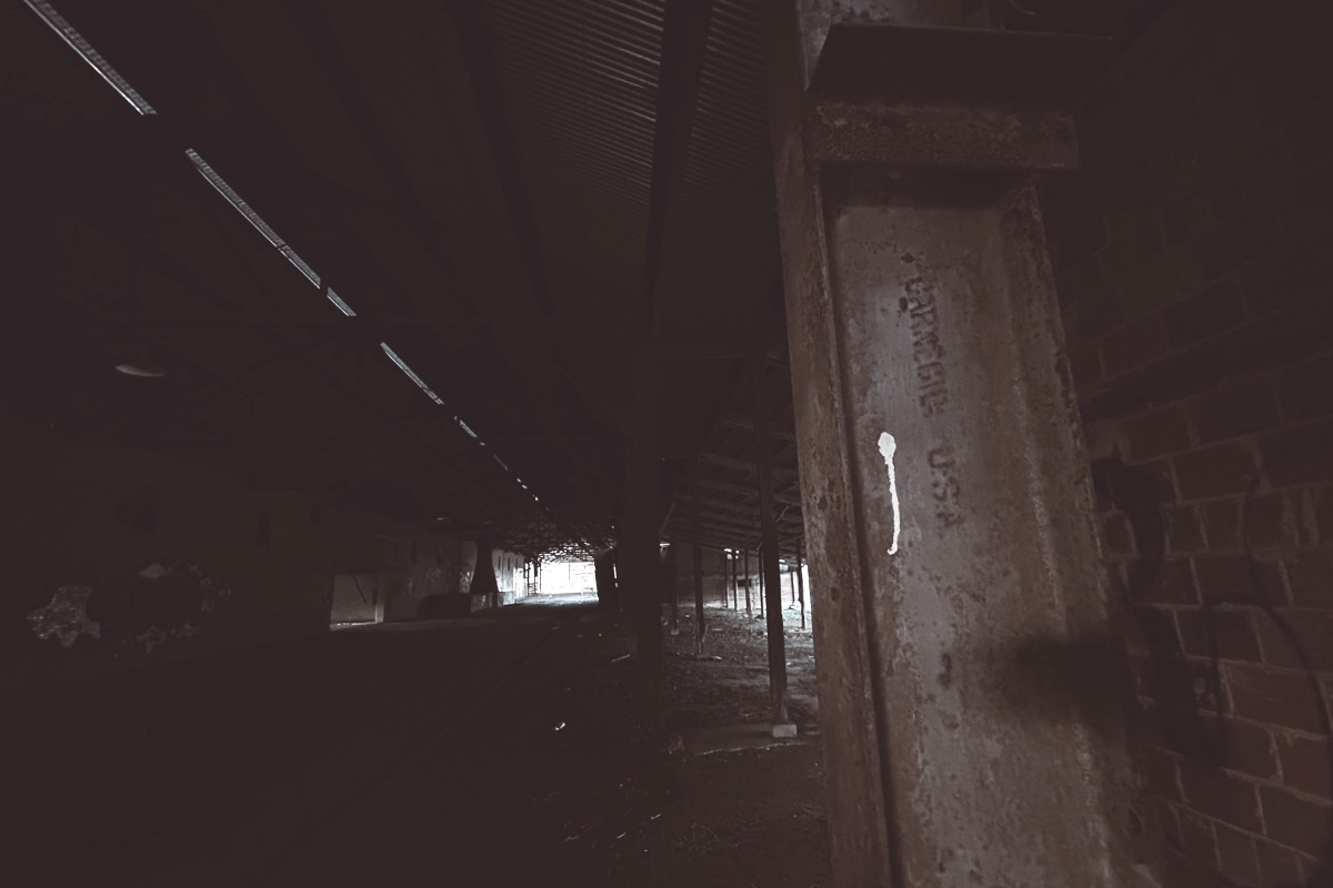 A disused industrial hall with a steel column stamped Carnegie U.S.A.