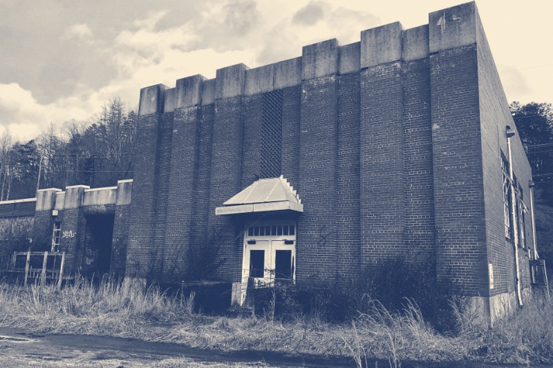 The brick exterior of a disused school gymnasium, in a warm duotone