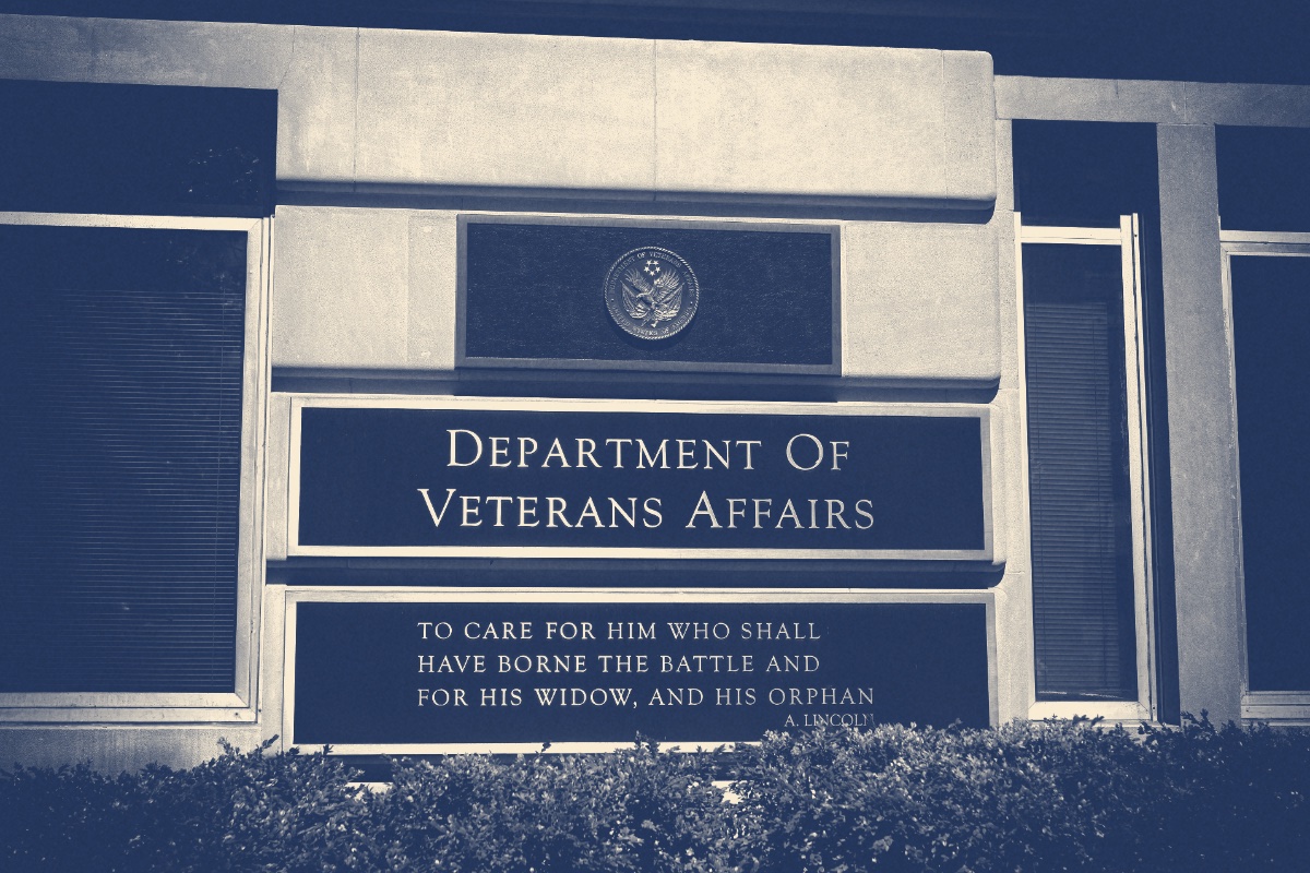 The bronze plaques outside the Department of Veterans Affairs headquarters in Washington, the department seal above its name and Lincoln's words beneath, in a slate and bone duotone