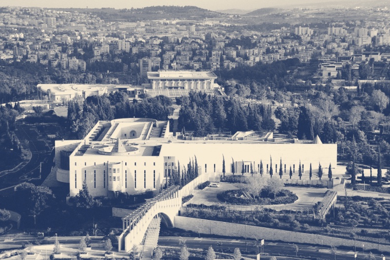 The Supreme Court of Israel in Jerusalem seen from above among cypress trees, the Knesset on the rise behind it, in a slate and bone duotone