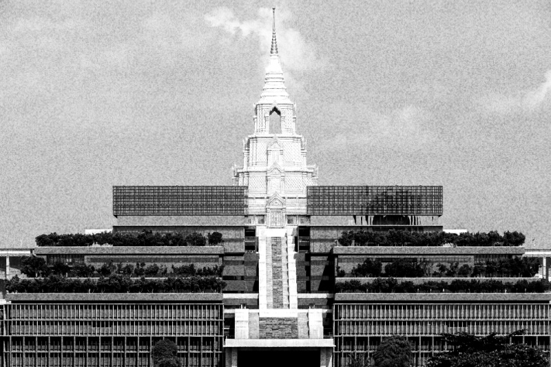The Sappaya-Sapasathan parliament building in Bangkok, tiers of terraces and glass rising to a tall spired tower at its centre, in high contrast black and white with coarse grain
