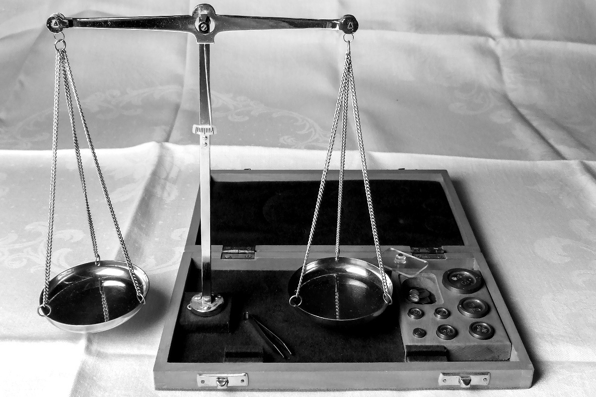 A balance scale with brass weights, banded in the house treatment