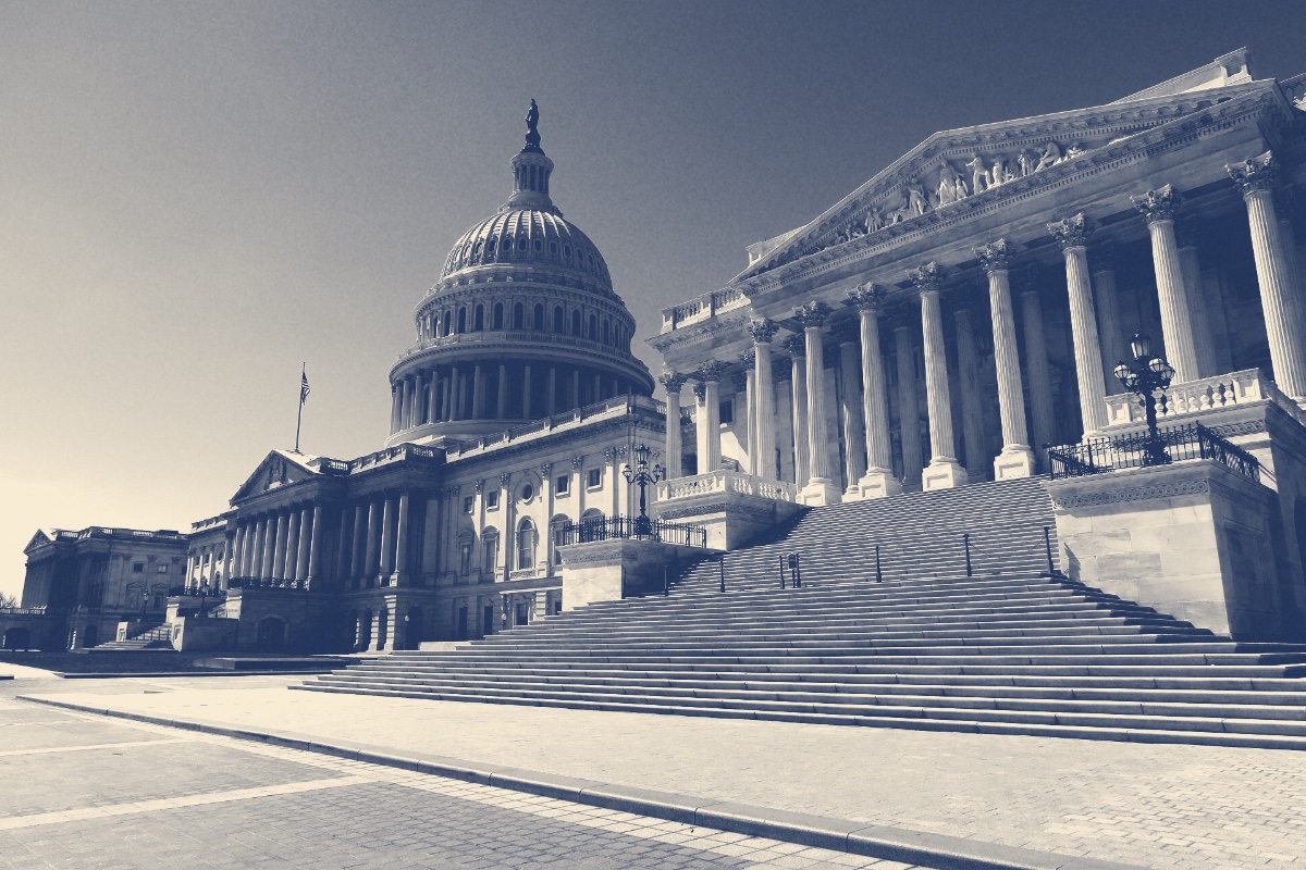 The east front of the United States Capitol seen from the northeast beneath a clear sky, in a slate and bone duotone