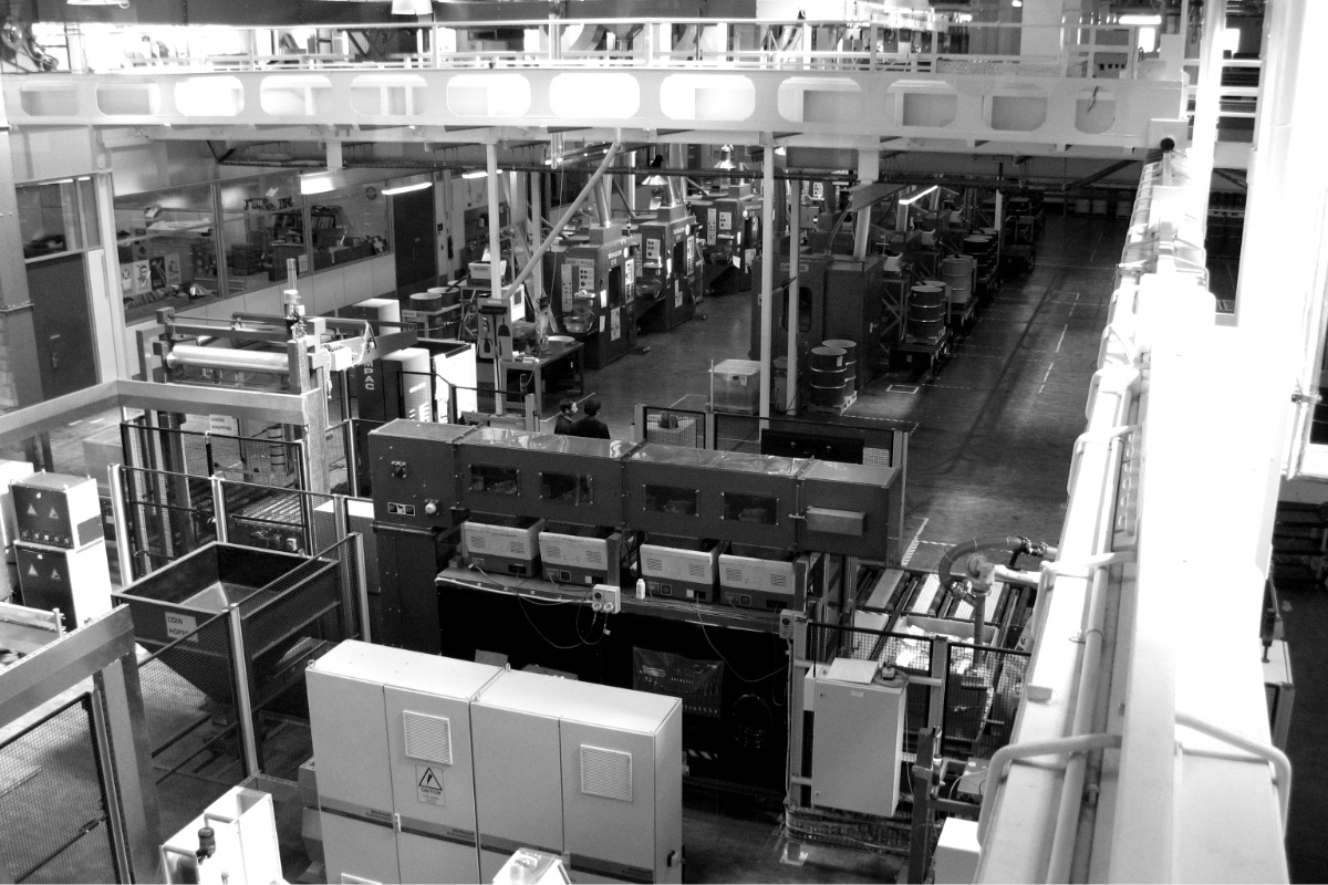 A modern coining hall seen from a gallery above, in plain black and white