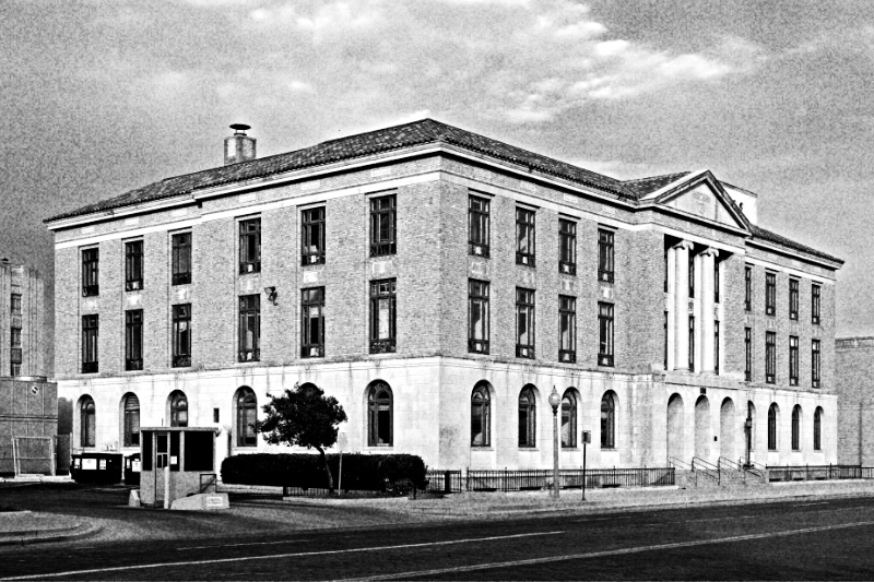 The old federal courthouse in Lubbock, Texas, a stone building with tall arched windows, in high-contrast black and white with visible grain