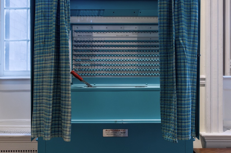 A voting booth with a privacy curtain in a polling place