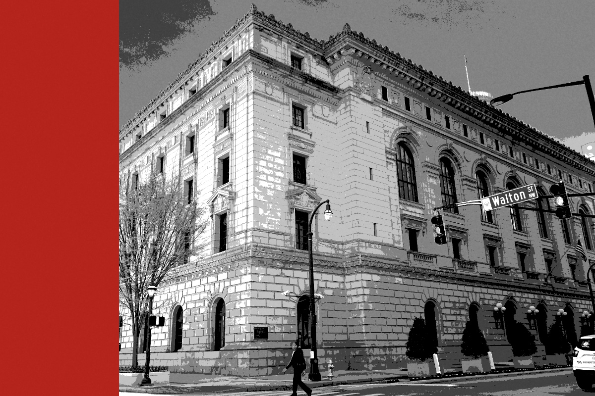 The Elbert P. Tuttle Court of Appeals Building in Atlanta, a granite Renaissance Revival block on a street corner with arched windows, a street lamp and traffic lights, and a pedestrian crossing in front, in near black and white with a flat red band down the left edge
