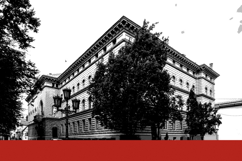 The Saeima building in Riga, a long ochre and cream Renaissance Revival palazzo on a cobbled corner, with a tree and an iron street lamp in front, in near black and white with a flat red band along the foot of the frame