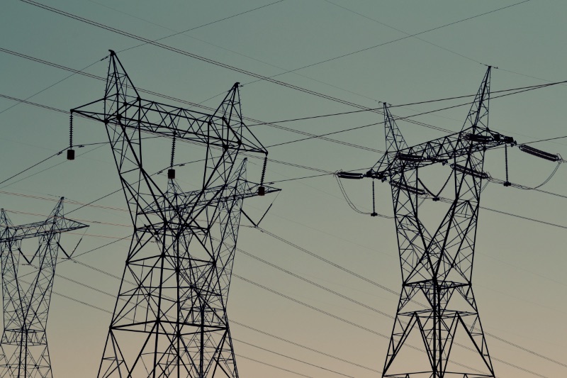 Black transmission towers under green sky